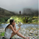 Girl reading a book by a stream